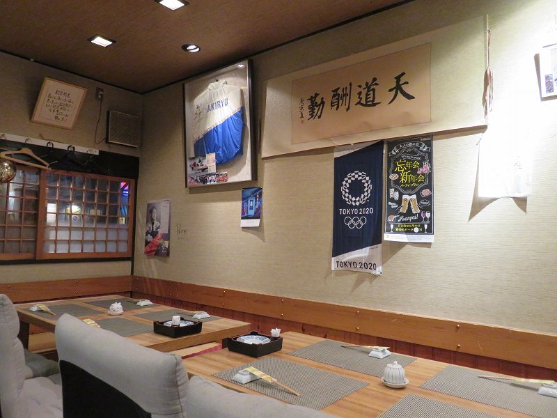「鮨dining松雪」のテーブル席と、桐生順平選手のサイン入りジャンパー